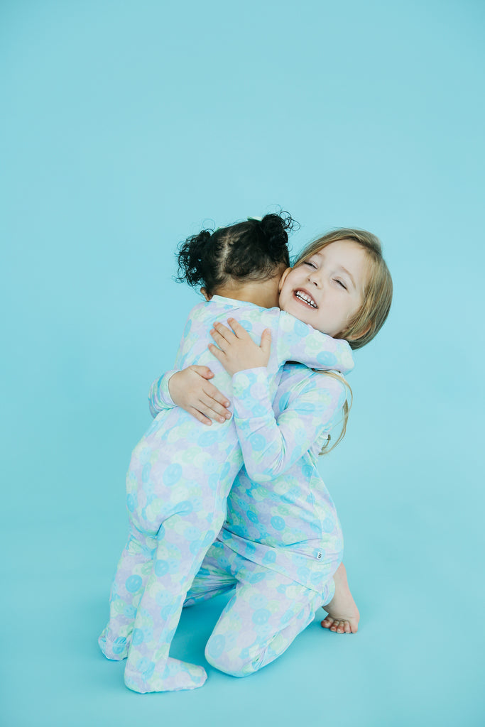 Siblings Hugging in Smiley Face Pajamas